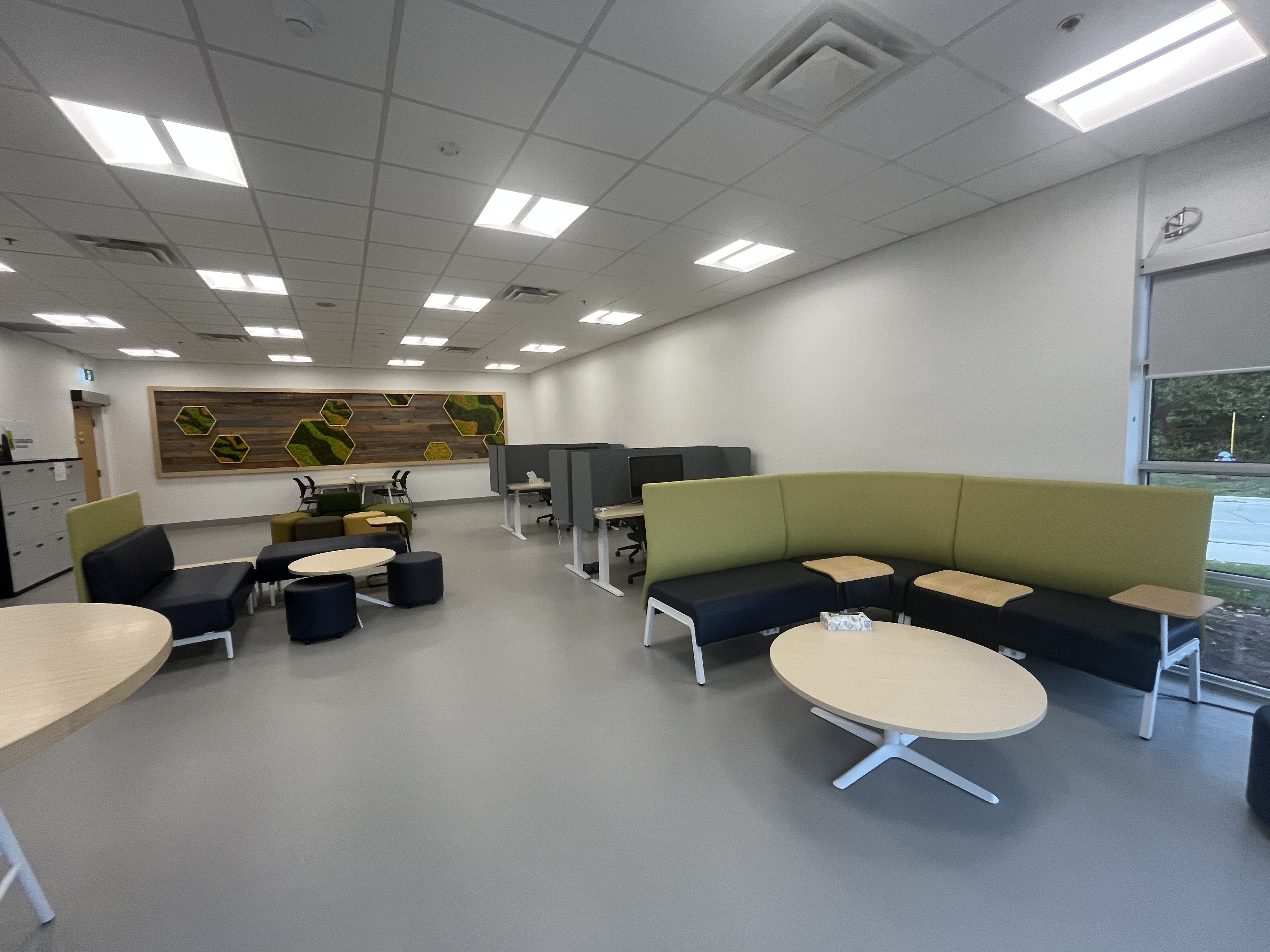 The collaborative studio space features modular seating, soft lighting, and flexible workstations designed for group ideation and fabrication planning.